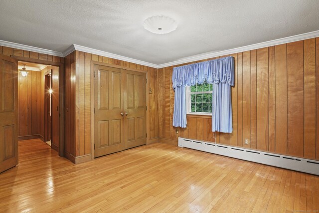 870 N Colony Rd, Meriden, CT 06450 - spare room with a baseboard heating unit, wood-type flooring, crown molding, wood walls, and a textured ceiling