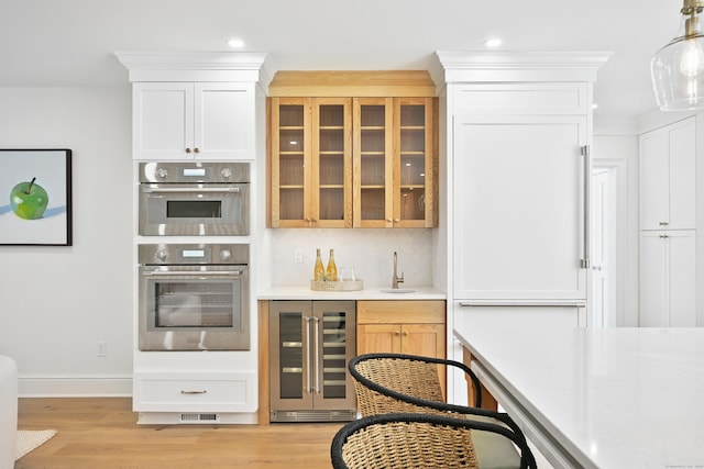 181 Highland Ave, Norwalk, CT 06853 - kitchen featuring wine cooler, light countertops, light wood-style flooring, double oven, and recessed lighting