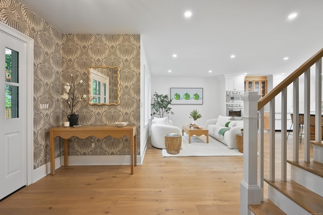 181 Highland Ave, Norwalk, CT 06853 - entryway with wallpapered walls, recessed lighting, wood finished floors, stairs, and a fireplace