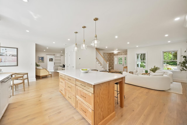 181 Highland Ave, Norwalk, CT 06853 - kitchen with open floor plan, light wood-style flooring, a barn door, recessed lighting, and a kitchen island