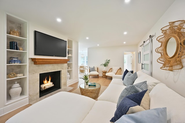 181 Highland Ave, Norwalk, CT 06853 - living room with wood finished floors, a barn door, a premium fireplace, recessed lighting, and built in features
