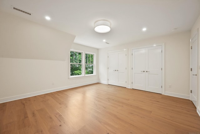 181 Highland Ave, Norwalk, CT 06853 - unfurnished bedroom with two closets, light wood-style flooring, and recessed lighting