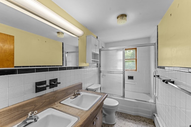 46 Newberry Rd, East Windsor, CT 06088 - full bath with tile walls, tile patterned floors, toilet, a wainscoted wall, and combined bath / shower with glass door