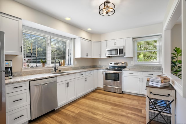17 Hollow Tree Ln Unit 17, Monroe, CT 06468 - kitchen featuring appliances with stainless steel finishes, a sink, white cabinets, light wood-style flooring, and recessed lighting