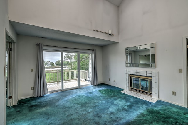74 Quarry Dock Rd Unit 74, Branford, CT 06405 - unfurnished living room featuring carpet, a tiled fireplace, a towering ceiling, and baseboards