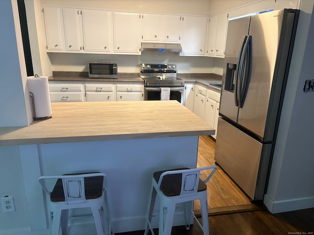 11 Arden Ave, New Fairfield, CT 06812 - kitchen featuring stainless steel appliances, under cabinet range hood, a peninsula, dark wood-type flooring, and white cabinetry