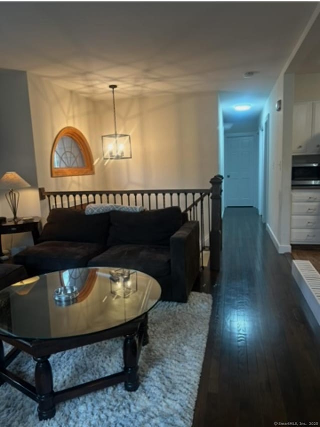11 Arden Ave, New Fairfield, CT 06812 - living area featuring dark wood finished floors, a chandelier, and baseboards