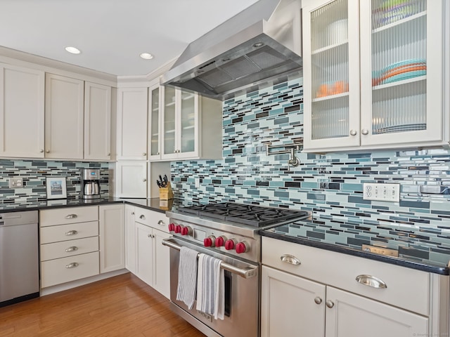 48 Harbor View Ave, Norwalk, CT 06854 - kitchen featuring designer stove, wall chimney exhaust hood, decorative backsplash, dark countertops, and recessed lighting
