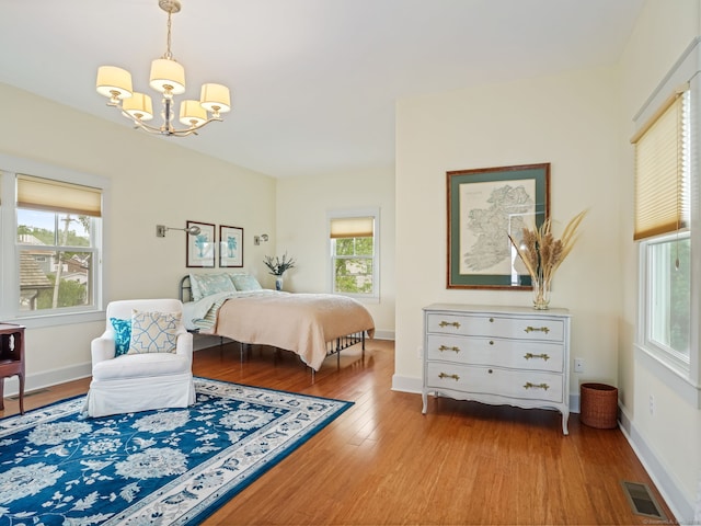 48 Harbor View Ave, Norwalk, CT 06854 - bedroom with a chandelier, wood finished floors, multiple windows, and baseboards
