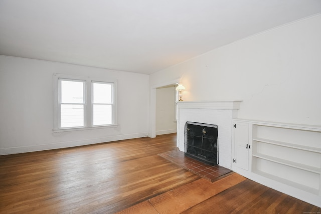 497 Commonwealth Ave, New Britain, CT 06053 - unfurnished living room featuring a fireplace, wood finished floors, baseboards, and built in features