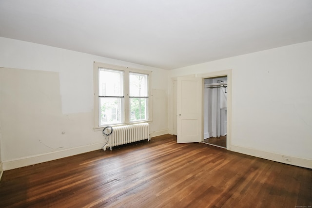 497 Commonwealth Ave, New Britain, CT 06053 - unfurnished bedroom with radiator heating unit, wood finished floors, baseboards, and a closet