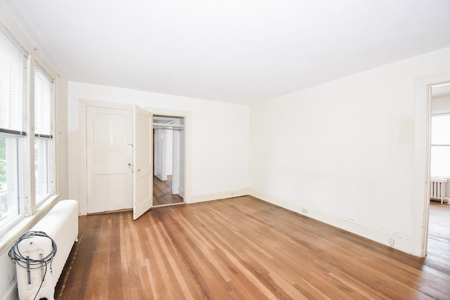 497 Commonwealth Ave, New Britain, CT 06053 - empty room with radiator heating unit, light wood-type flooring, and baseboards