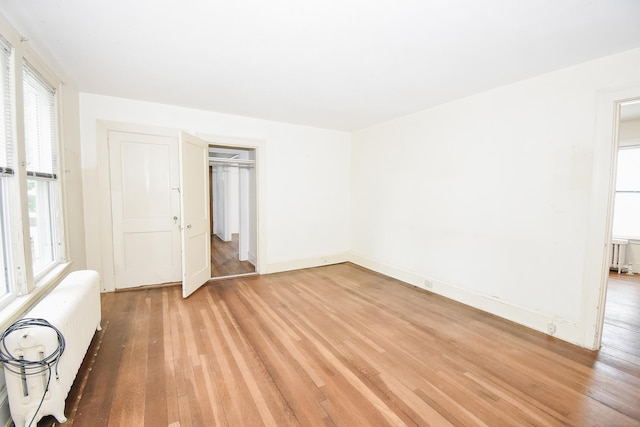 497 Commonwealth Ave, New Britain, CT 06053 - unfurnished room featuring radiator heating unit, light wood-type flooring, and baseboards
