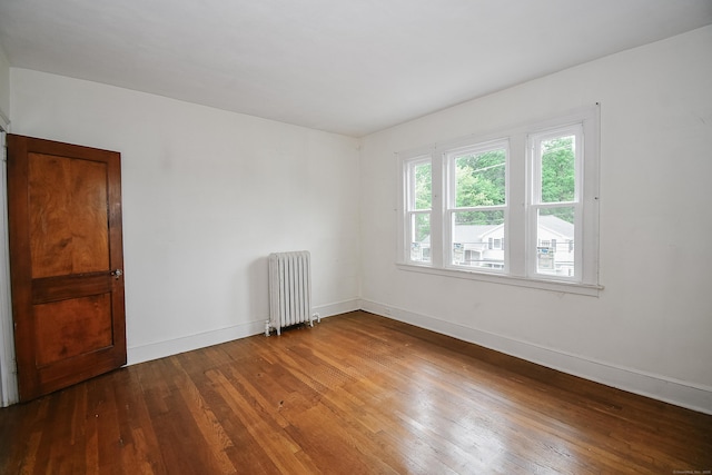 497 Commonwealth Ave, New Britain, CT 06053 - spare room with radiator heating unit, hardwood / wood-style floors, and baseboards
