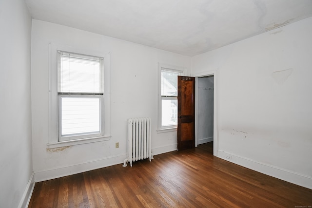 497 Commonwealth Ave, New Britain, CT 06053 - empty room with radiator, healthy amount of natural light, wood finished floors, and baseboards