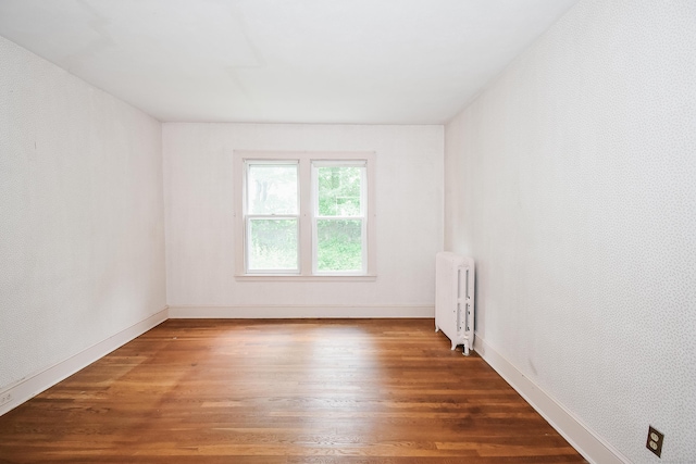 497 Commonwealth Ave, New Britain, CT 06053 - empty room with radiator heating unit, wood finished floors, and baseboards