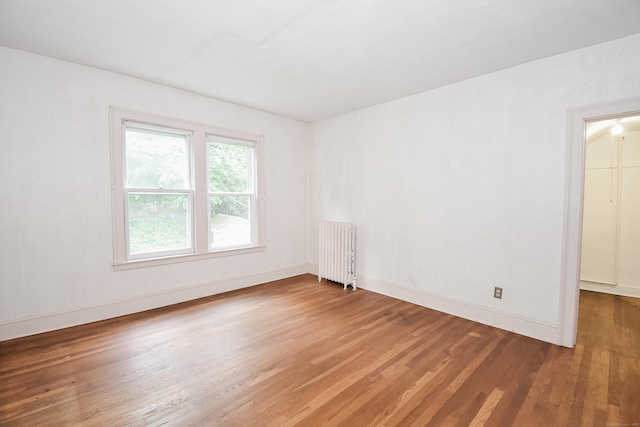 497 Commonwealth Ave, New Britain, CT 06053 - unfurnished room featuring radiator, wood finished floors, and baseboards