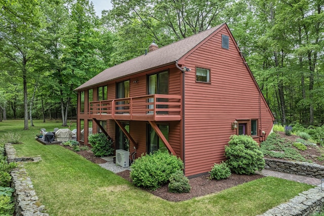 31 Philip Dr, Mansfield, CT 06268 - view of side of home with a deck, a lawn, a cooling unit, a chimney, and roof with shingles
