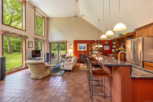 31 Philip Dr, Mansfield, CT 06268 - kitchen with high quality fridge, high vaulted ceiling, ceiling fan, brown cabinets, and dark tile patterned flooring