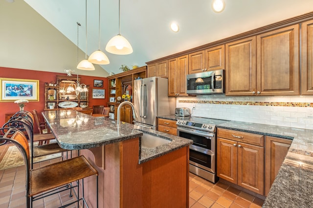 31 Philip Dr, Mansfield, CT 06268 - kitchen featuring stainless steel appliances, a sink, brown cabinets, an island with sink, and vaulted ceiling