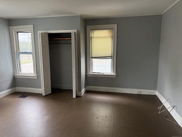 297 Laurel Ave, Bridgeport, CT 06605 - unfurnished bedroom with crown molding, baseboards, dark wood finished floors, and a closet