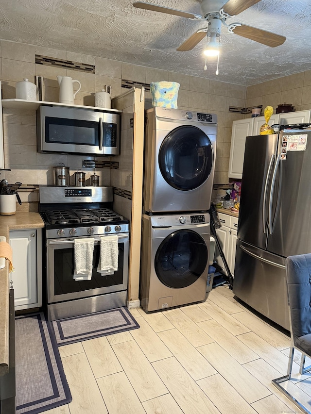 297 Laurel Ave, Bridgeport, CT 06605 - kitchen featuring stainless steel appliances, estacked washer and dryer, ceiling fan, white cabinets, and light countertops
