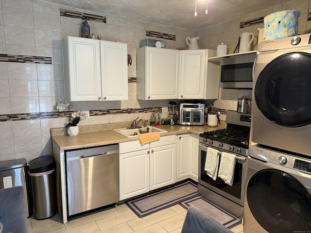 297 Laurel Ave, Bridgeport, CT 06605 - kitchen with stainless steel appliances, a sink, stacked washer / drying machine, light countertops, and white cabinets