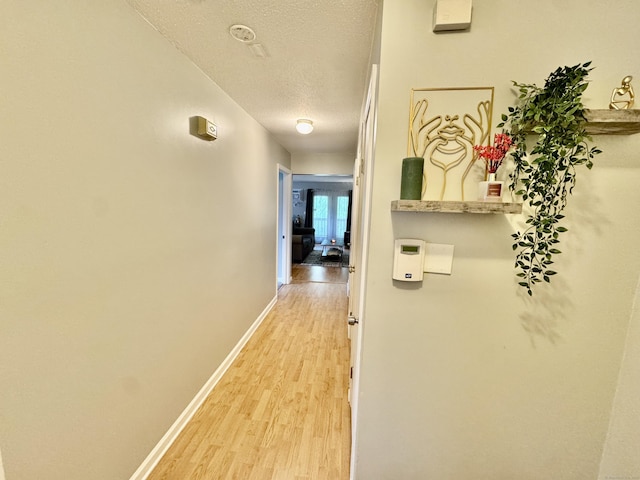 140 Hamden Ave Apt C, Waterbury, CT 06704 - corridor featuring a textured ceiling, light wood finished floors, and baseboards