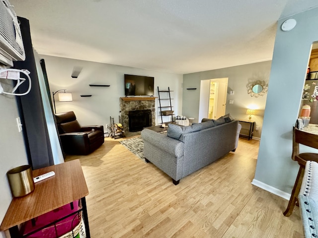 140 Hamden Ave Apt C, Waterbury, CT 06704 - living room featuring light wood-type flooring, a stone fireplace, and baseboards