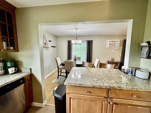 140 Hamden Ave Apt C, Waterbury, CT 06704 - kitchen with dishwasher, a chandelier, a wall mounted AC, light stone counters, and glass insert cabinets
