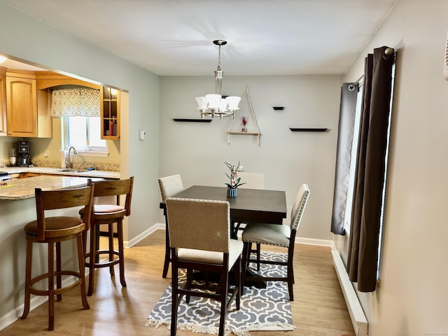 140 Hamden Ave Apt C, Waterbury, CT 06704 - dining room with a chandelier, light wood-style floors, and baseboards