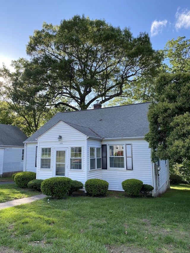 154 Wall St, Meriden, CT 06475 - view of front of house featuring a chimney, a front yard, and roof with shingles