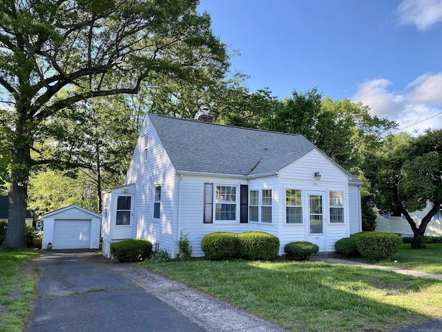 154 Wall St, Meriden, CT 06475 - view of front facade with an outbuilding, roof with shingles, a chimney, asphalt driveway, and a front yard