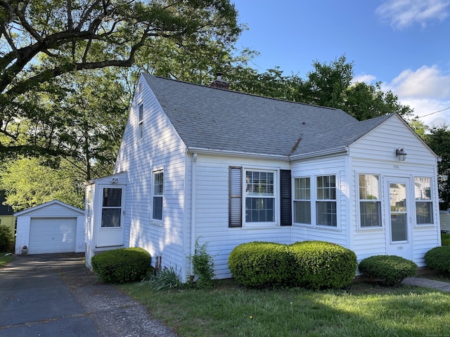 154 Wall St, Meriden, CT 06475 - view of front of home featuring an outdoor structure, a shingled roof, driveway, a chimney, and a detached garage