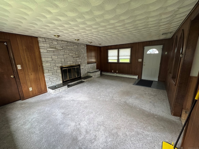 15 Zolan Dr, East Haven, CT 06513 - unfurnished living room featuring baseboard heating, wood walls, a fireplace, and carpet flooring