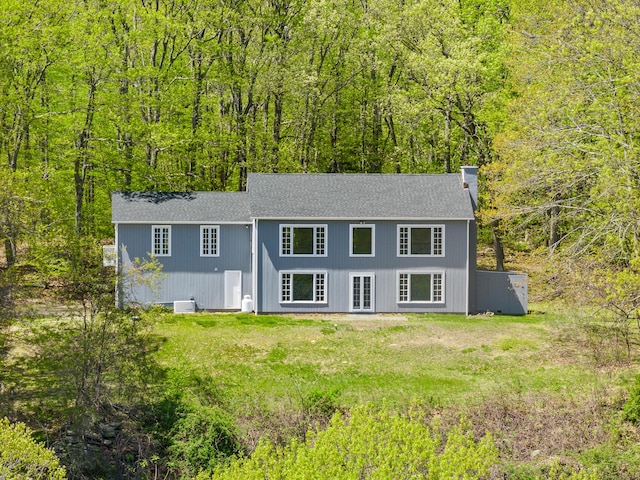 24 Newtown Tpke, Redding, CT 06896 - view of front facade featuring a chimney, a wooded view, and roof with shingles
