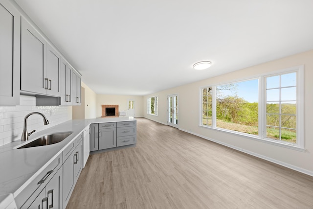 24 Newtown Tpke, Redding, CT 06896 - kitchen with a sink, gray cabinetry, light wood-style floors, a peninsula, and baseboards