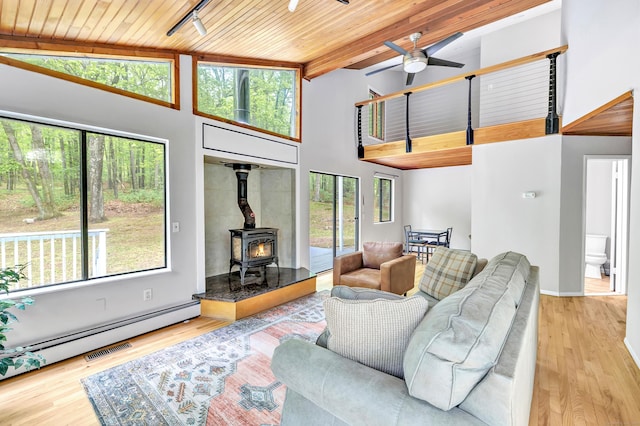 32 Old Bethel Rd, Newtown, CT 06470 - living area with high vaulted ceiling, a wood stove, wooden ceiling with exposed beams, ceiling fan, and wood finished floors