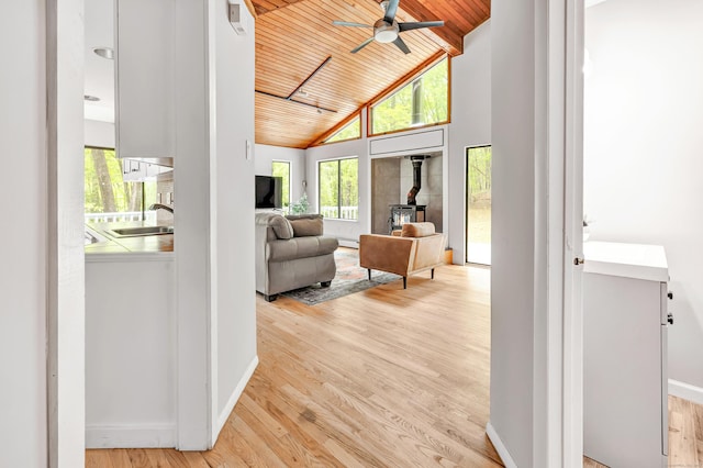 32 Old Bethel Rd, Newtown, CT 06470 - living area featuring a wood stove, wooden ceiling, a ceiling fan, light wood-style flooring, and baseboards