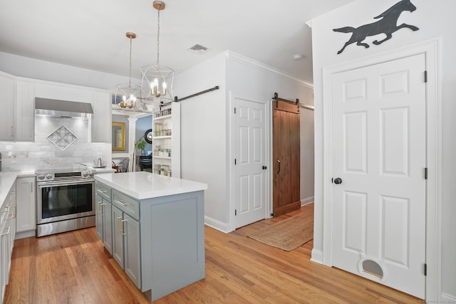 kitchen with electric range, a barn door, gray cabinetry, a chandelier, and light countertops