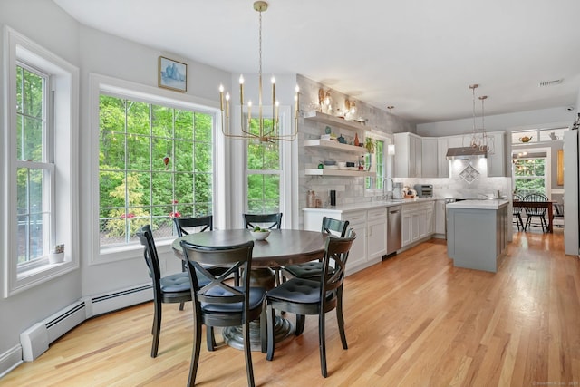 dining room featuring baseboard heating, a chandelier, and light wood-style flooring