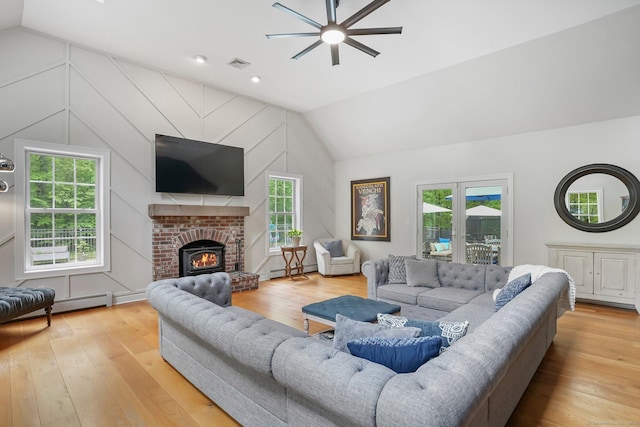 living area with lofted ceiling, ceiling fan, hardwood / wood-style floors, and healthy amount of natural light