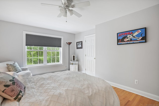 bedroom featuring wood finished floors, baseboards, and a ceiling fan