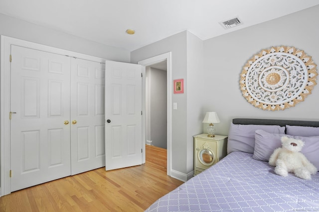 bedroom featuring light wood finished floors, a closet, and baseboards
