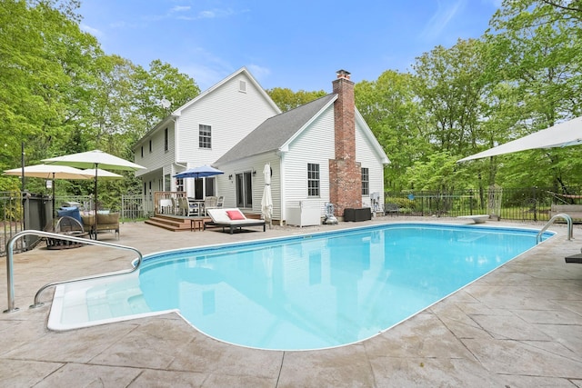view of swimming pool with a deck and a patio
