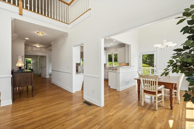7 Wyndemere Unit 7, Avon, CT 06001 - dining area with a chandelier, ornamental molding, light wood-type flooring, a towering ceiling, and baseboards