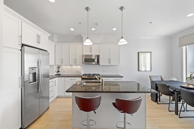 442 Main Ave Unit 18 B6, Norwalk, CT 06851 - kitchen featuring stainless steel appliances, ornamental molding, decorative backsplash, a kitchen island with sink, and light wood finished floors