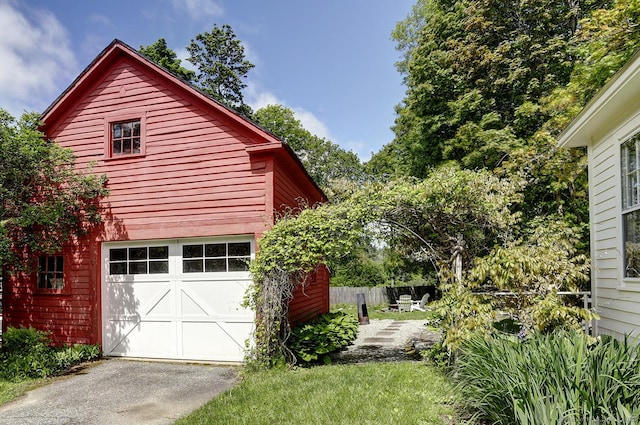view of side of home featuring driveway and a garage