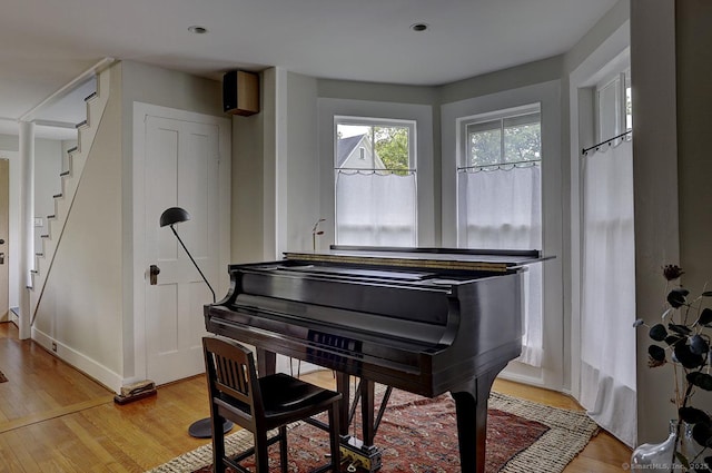 living area with light wood finished floors, stairway, and baseboards