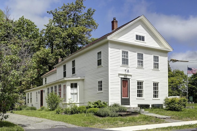 greek revival house featuring a chimney